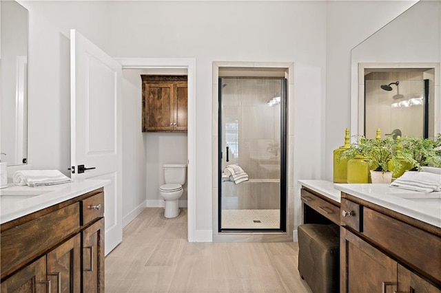 full bathroom with toilet, a stall shower, and two vanities