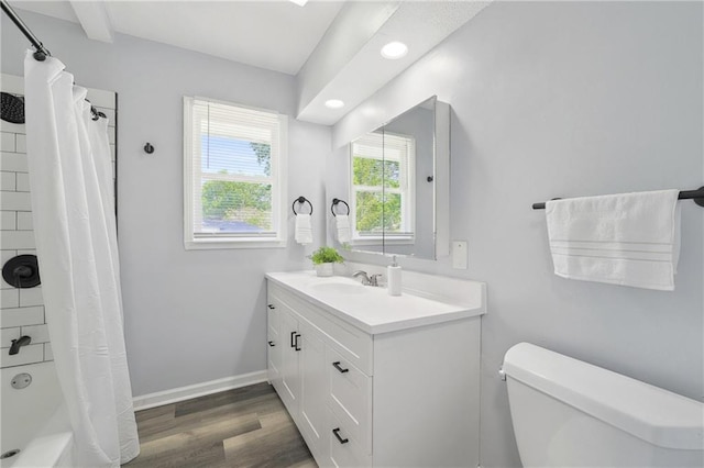 full bath featuring baseboards, toilet, wood finished floors, shower / bathtub combination with curtain, and vanity