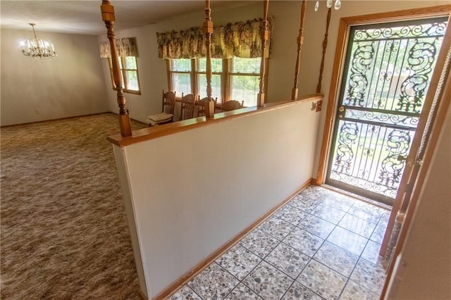 foyer entrance featuring an inviting chandelier and carpet flooring