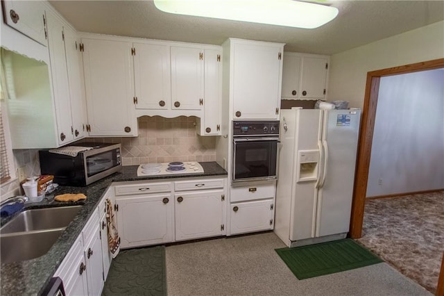 kitchen featuring white cabinetry, sink, backsplash, and white appliances