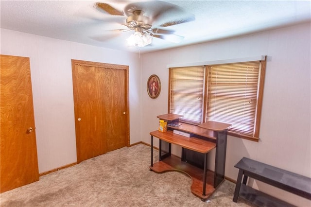 carpeted office featuring ceiling fan