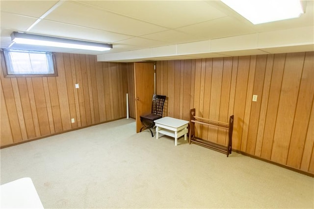 basement with light carpet and wooden walls