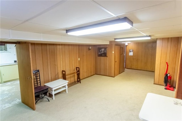 basement with light colored carpet and wood walls