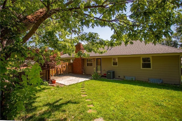 rear view of property featuring a yard, central air condition unit, and a patio area