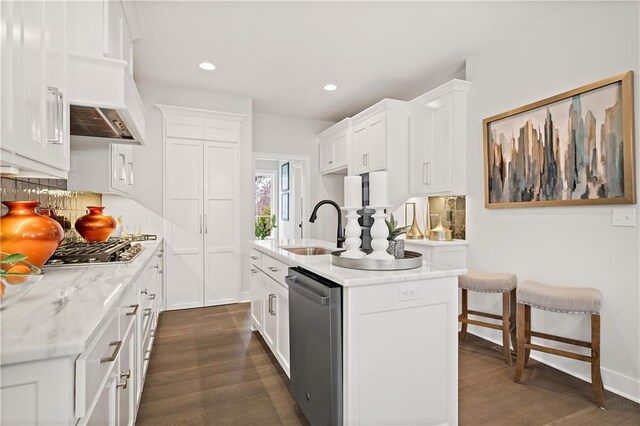 kitchen with white cabinets, dark wood-type flooring, appliances with stainless steel finishes, decorative backsplash, and sink