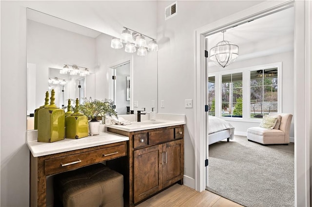 bathroom featuring wood-type flooring, vanity, and an inviting chandelier