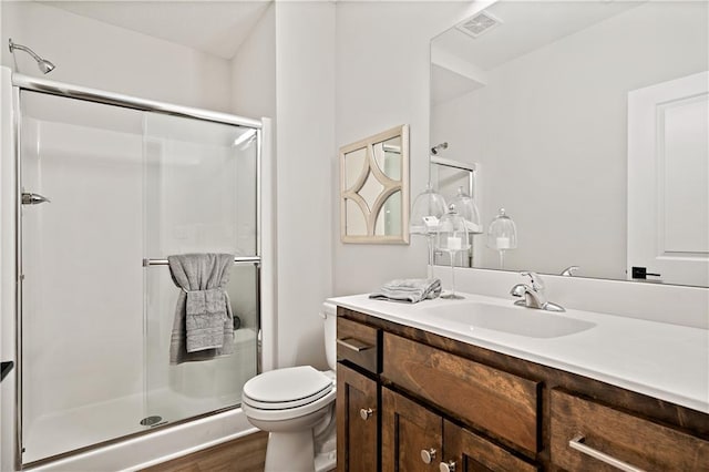 bathroom featuring vanity, walk in shower, hardwood / wood-style flooring, and toilet