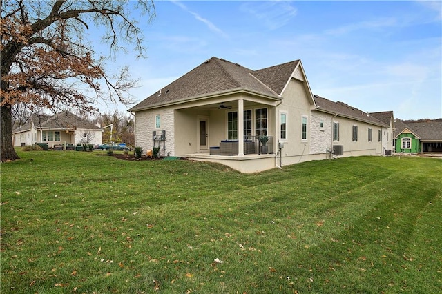 rear view of property featuring central AC, ceiling fan, a patio area, and a lawn