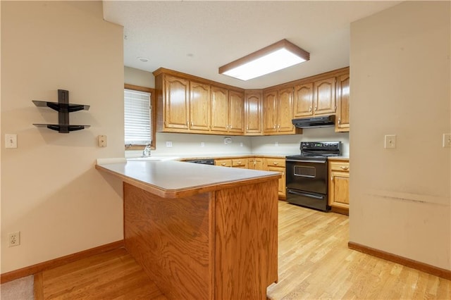 kitchen with black electric range, light wood-type flooring, and kitchen peninsula