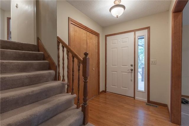 entrance foyer with a textured ceiling and light wood-type flooring