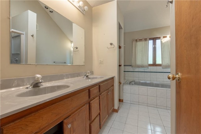 bathroom featuring vanity, lofted ceiling, tile patterned flooring, and tiled bath