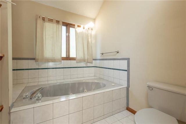 bathroom featuring vaulted ceiling, a relaxing tiled tub, toilet, and tile patterned flooring