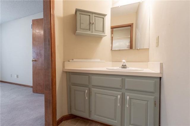 bathroom with vanity, a textured ceiling, and vaulted ceiling