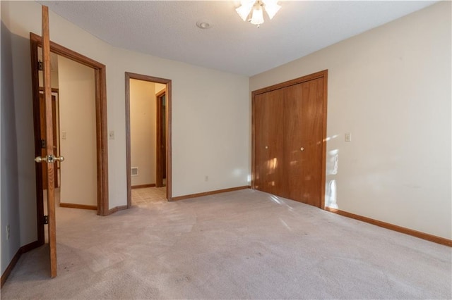 unfurnished bedroom with a closet and light colored carpet