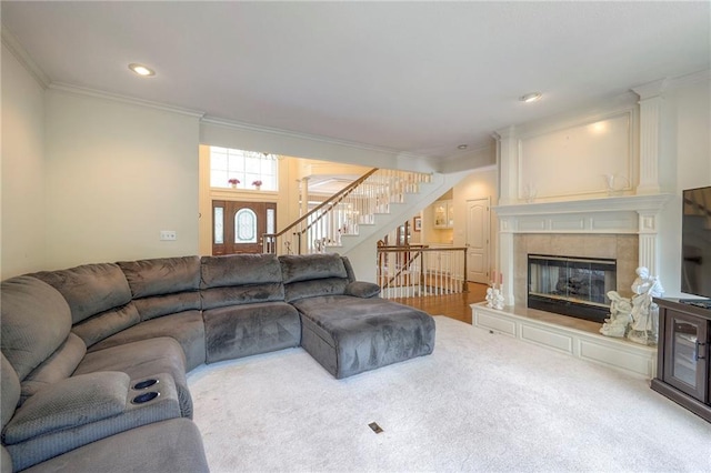 living room with a tiled fireplace and ornamental molding