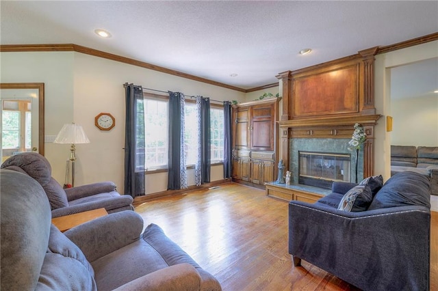 living room featuring crown molding, a high end fireplace, and light hardwood / wood-style flooring