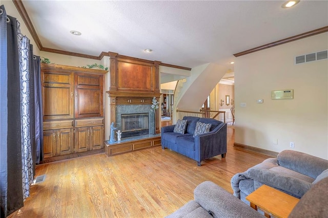 living room with crown molding, a high end fireplace, and light hardwood / wood-style flooring