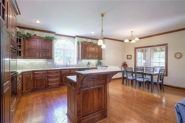 kitchen featuring sink, decorative light fixtures, a center island, dark hardwood / wood-style flooring, and backsplash