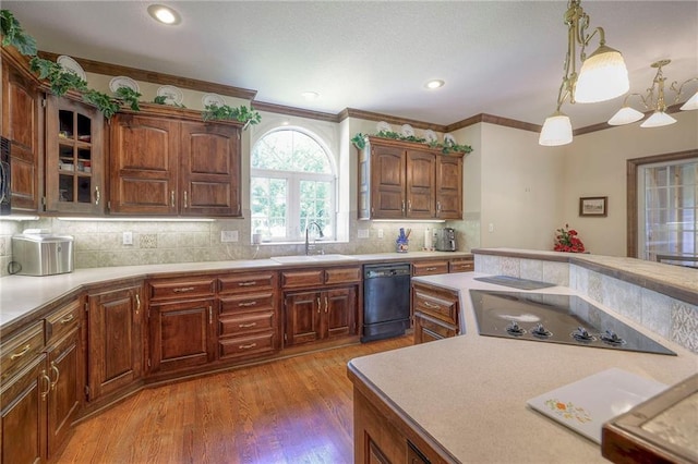 kitchen featuring sink, hardwood / wood-style floors, hanging light fixtures, backsplash, and black appliances