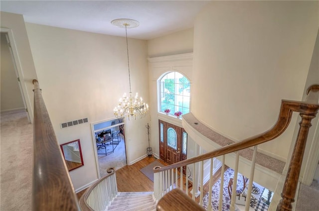 foyer featuring an inviting chandelier, hardwood / wood-style floors, and a high ceiling