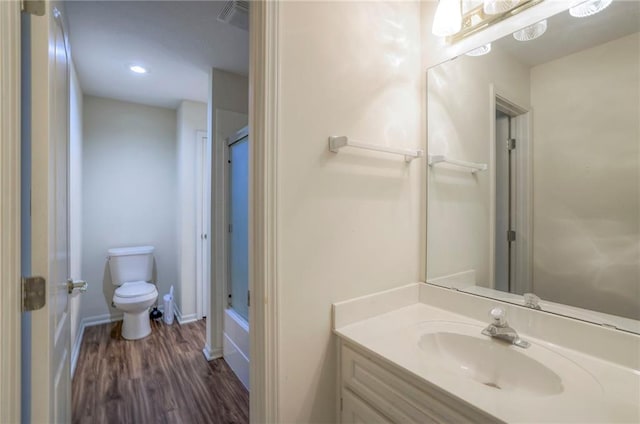 bathroom featuring walk in shower, vanity, toilet, and hardwood / wood-style floors