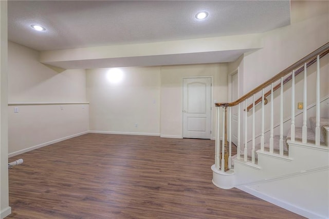 basement featuring dark hardwood / wood-style flooring and a textured ceiling