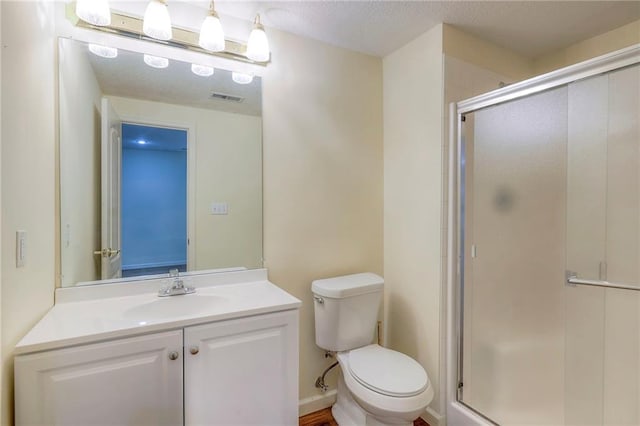 bathroom featuring walk in shower, vanity, and toilet