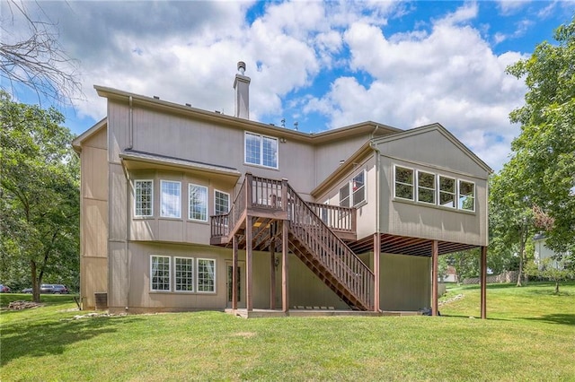 rear view of property featuring a deck and a lawn