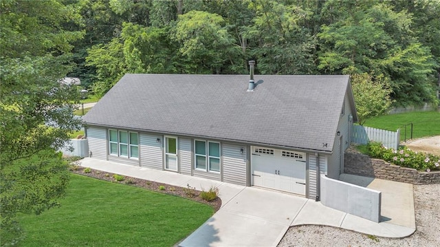 view of front of home featuring an attached garage, a front yard, and fence