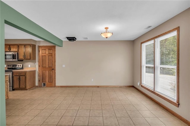 kitchen with visible vents, brown cabinets, appliances with stainless steel finishes, and light tile patterned flooring