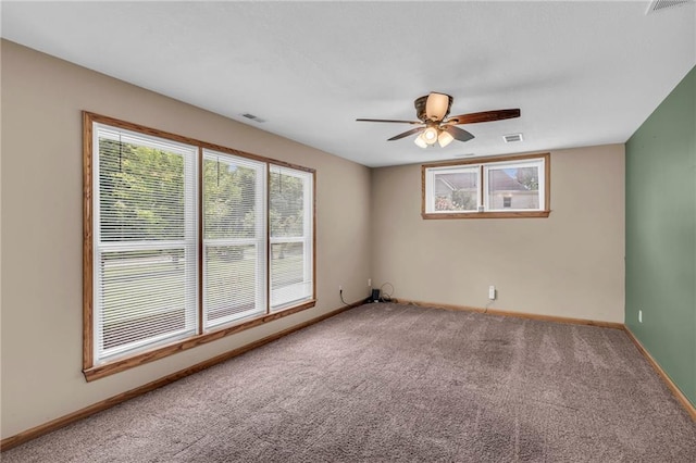 spare room with visible vents, carpet, baseboards, and ceiling fan