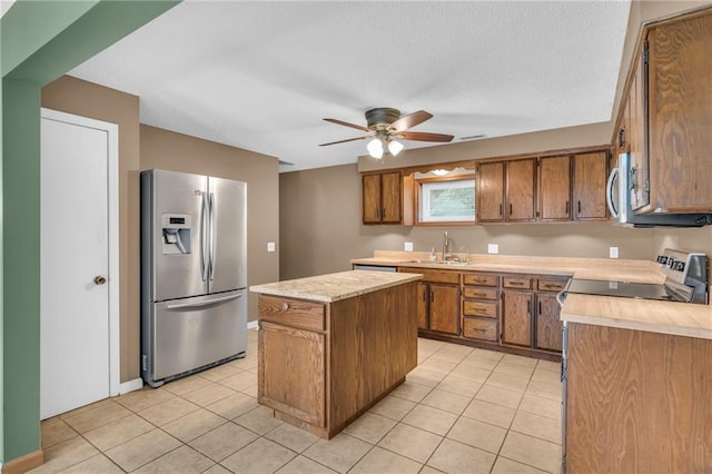 kitchen with a sink, brown cabinets, appliances with stainless steel finishes, and light countertops