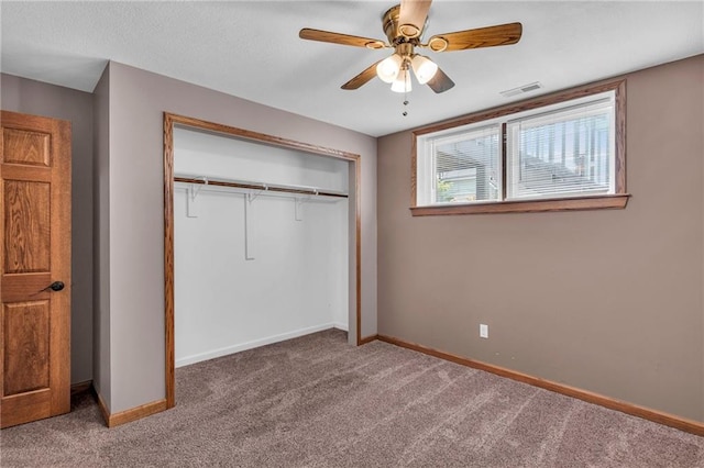 unfurnished bedroom featuring baseboards, visible vents, ceiling fan, a closet, and carpet flooring