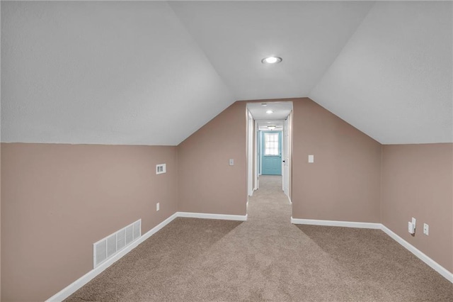 additional living space featuring visible vents, baseboards, carpet, and lofted ceiling