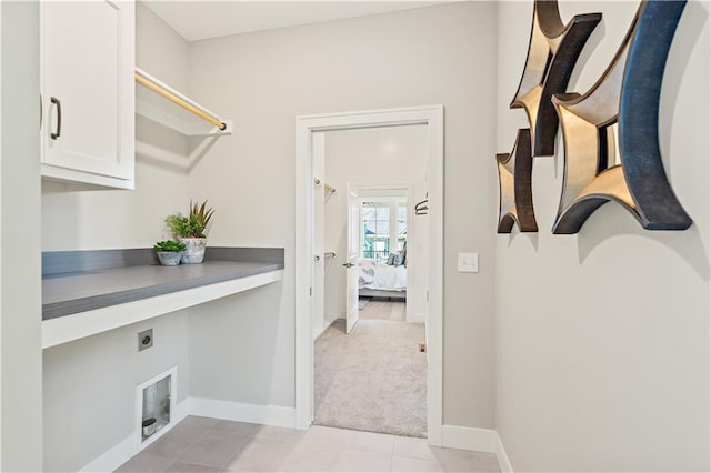 washroom with light colored carpet, cabinets, and hookup for an electric dryer