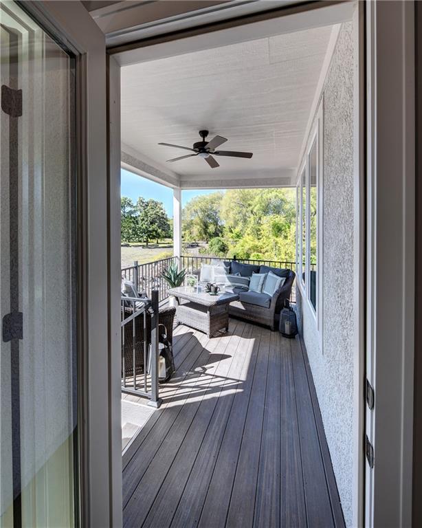 wooden deck with an outdoor hangout area and ceiling fan