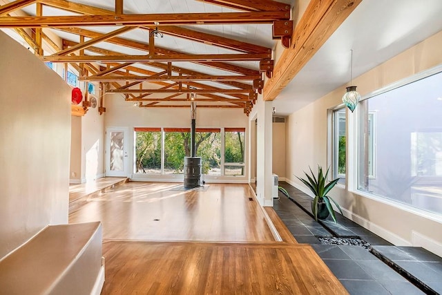 exercise area with dark wood-type flooring and high vaulted ceiling