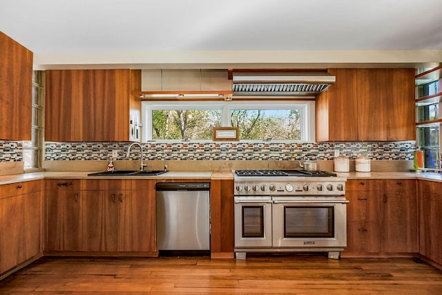 kitchen featuring backsplash, light wood-type flooring, sink, and appliances with stainless steel finishes