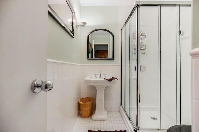 bathroom with tile patterned flooring, tile walls, and walk in shower