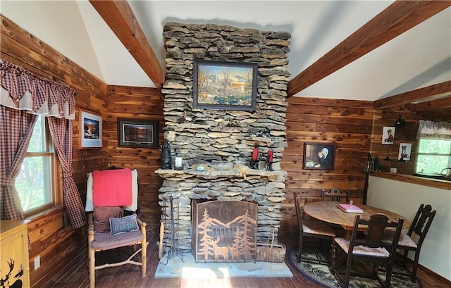 sitting room with hardwood / wood-style floors, vaulted ceiling with beams, a fireplace, and a wealth of natural light