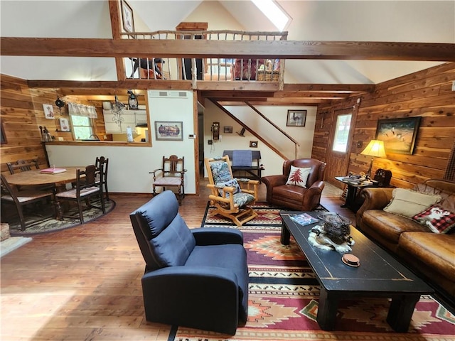 living room featuring hardwood / wood-style flooring, high vaulted ceiling, and wooden walls