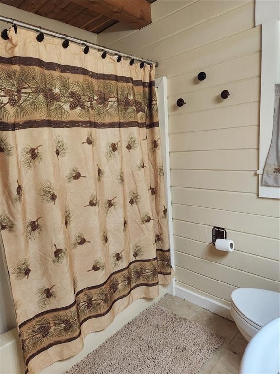 bathroom featuring toilet and wood walls