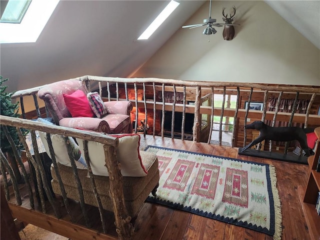 living area with hardwood / wood-style floors, ceiling fan, and high vaulted ceiling