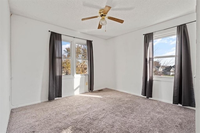 spare room with ceiling fan, carpet, and a textured ceiling