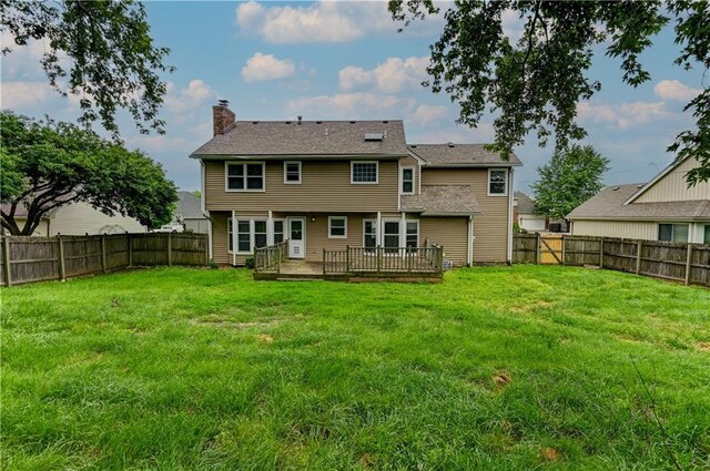 back of property featuring a wooden deck and a yard