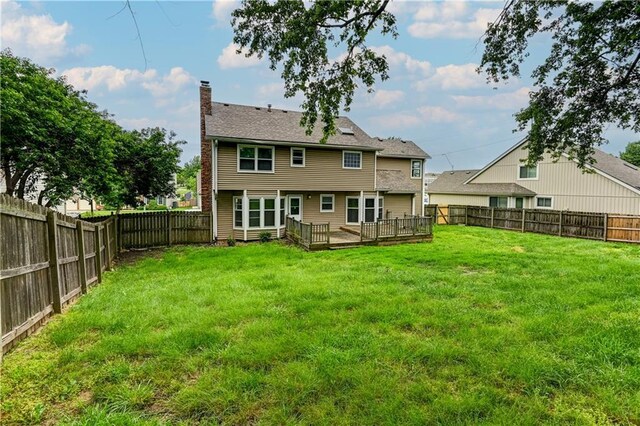 back of house featuring a yard and a deck