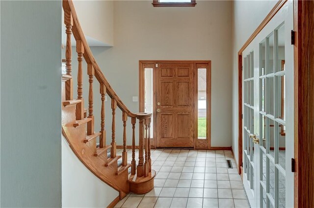 foyer with a high ceiling and light tile patterned flooring