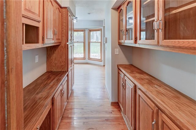 bar with butcher block countertops and light wood-type flooring