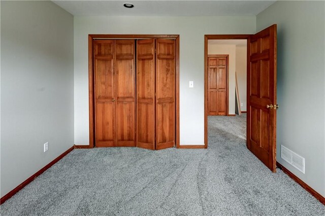 unfurnished bedroom featuring a closet and light carpet