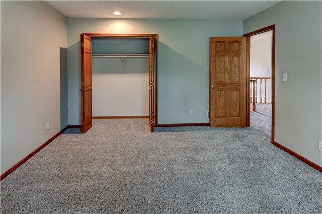 unfurnished bedroom featuring light carpet and a closet